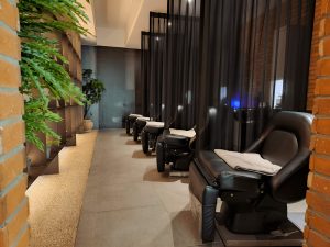 Современная мойка в окружении стильных кресел и мебели для мастеров